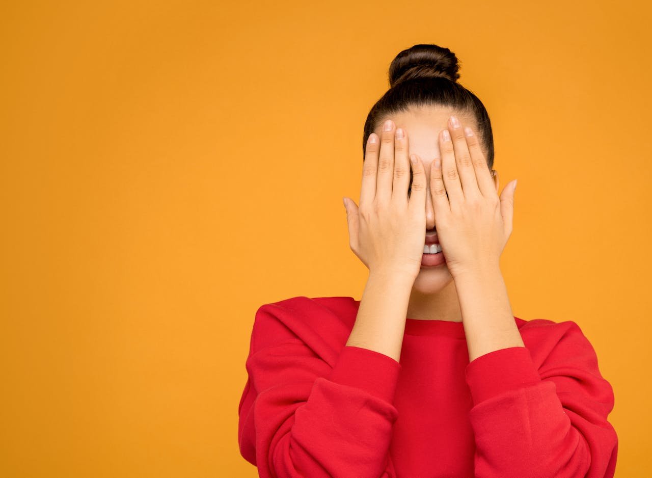 mujer tapándose la cara con las manos